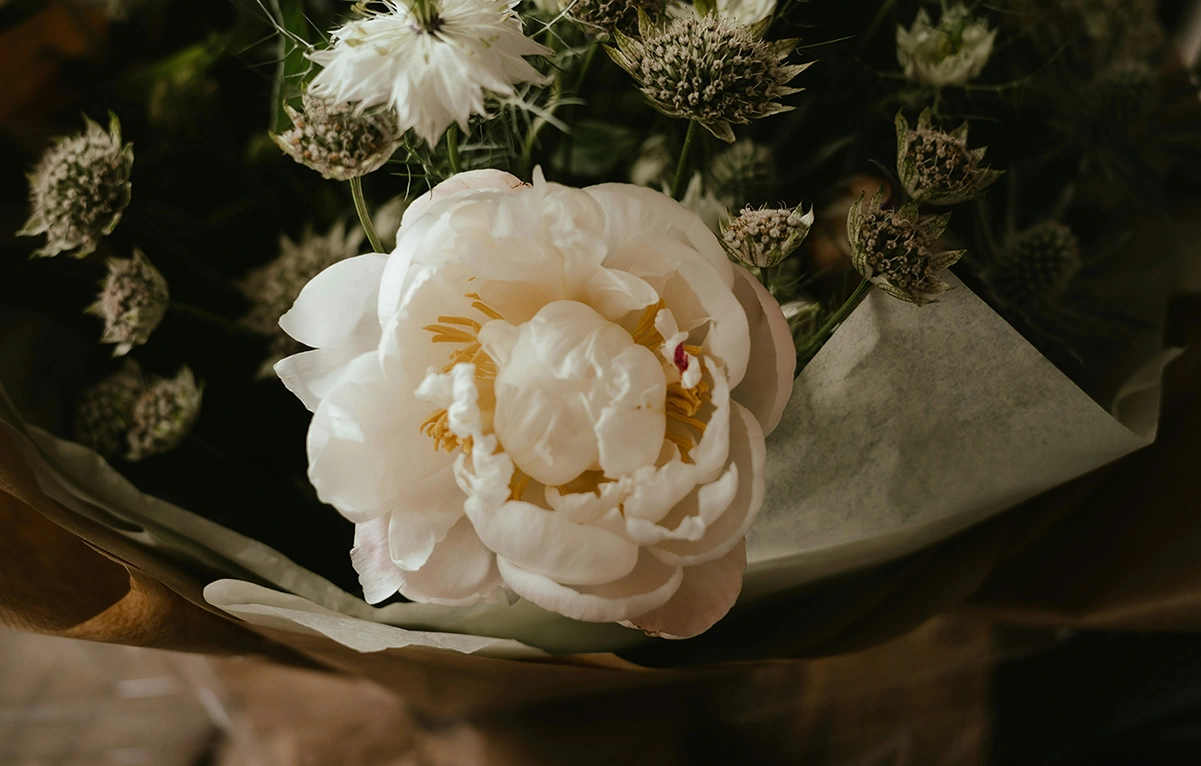 Bouquet posé sur une table avec une grande rose blanche